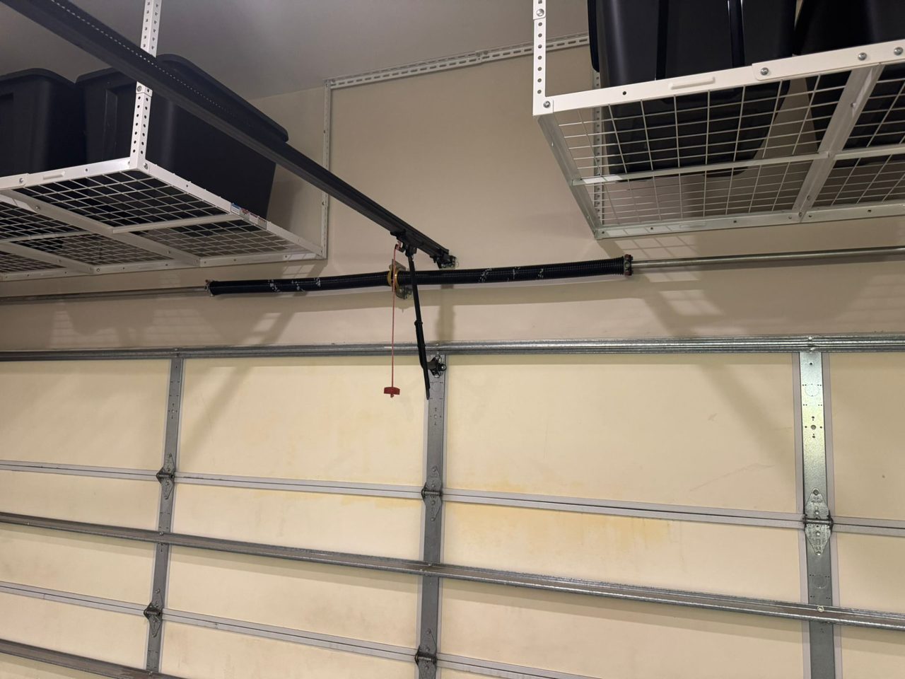 Torsion spring, shaft and cable drums installed above a finished garage door