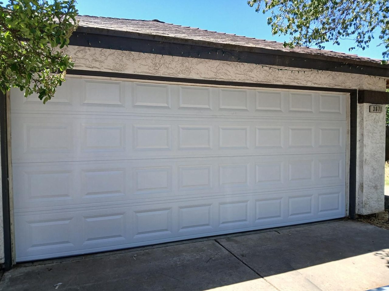 New white short-panel two-car garage door replacement on a Fresno area home