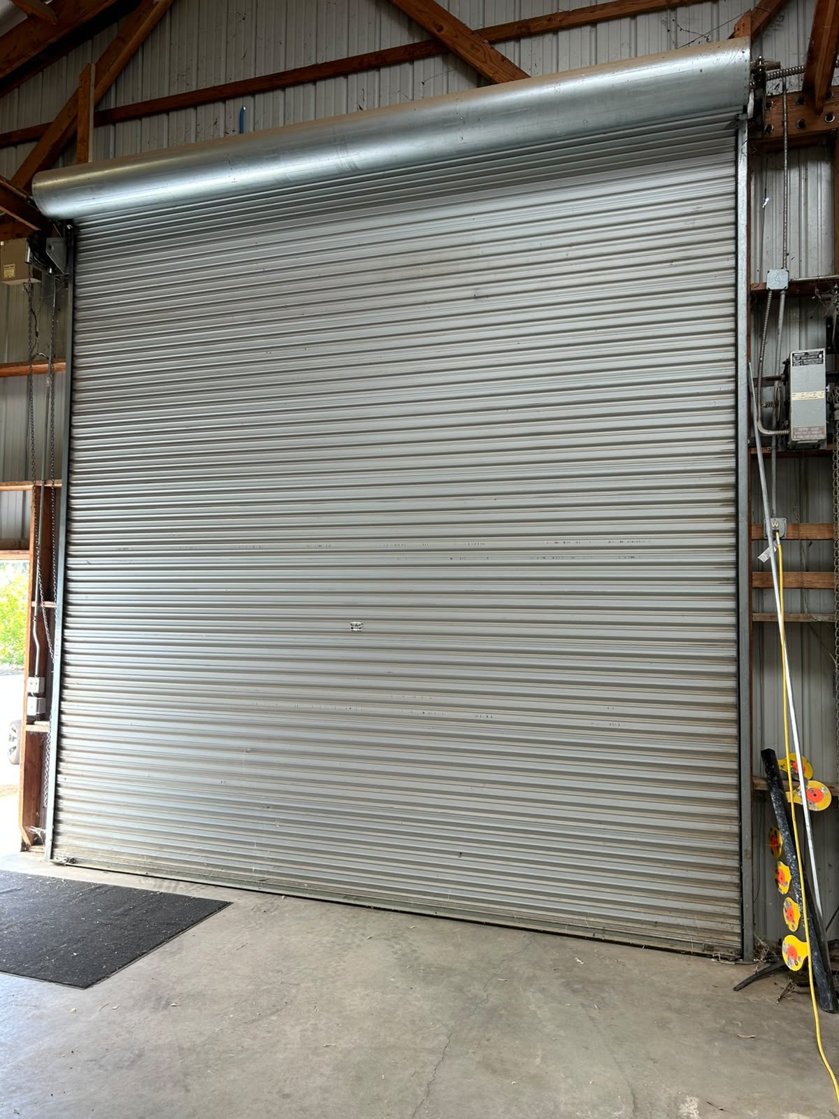 Commercial rolling steel roll-up door installed in a Fresno area warehouse with chain hoist operator
