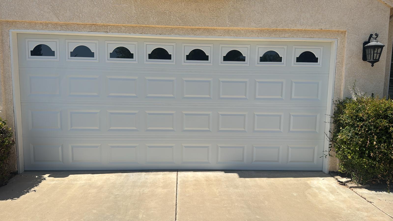 White garage door with arched window inserts installed on a home in Clovis, CA