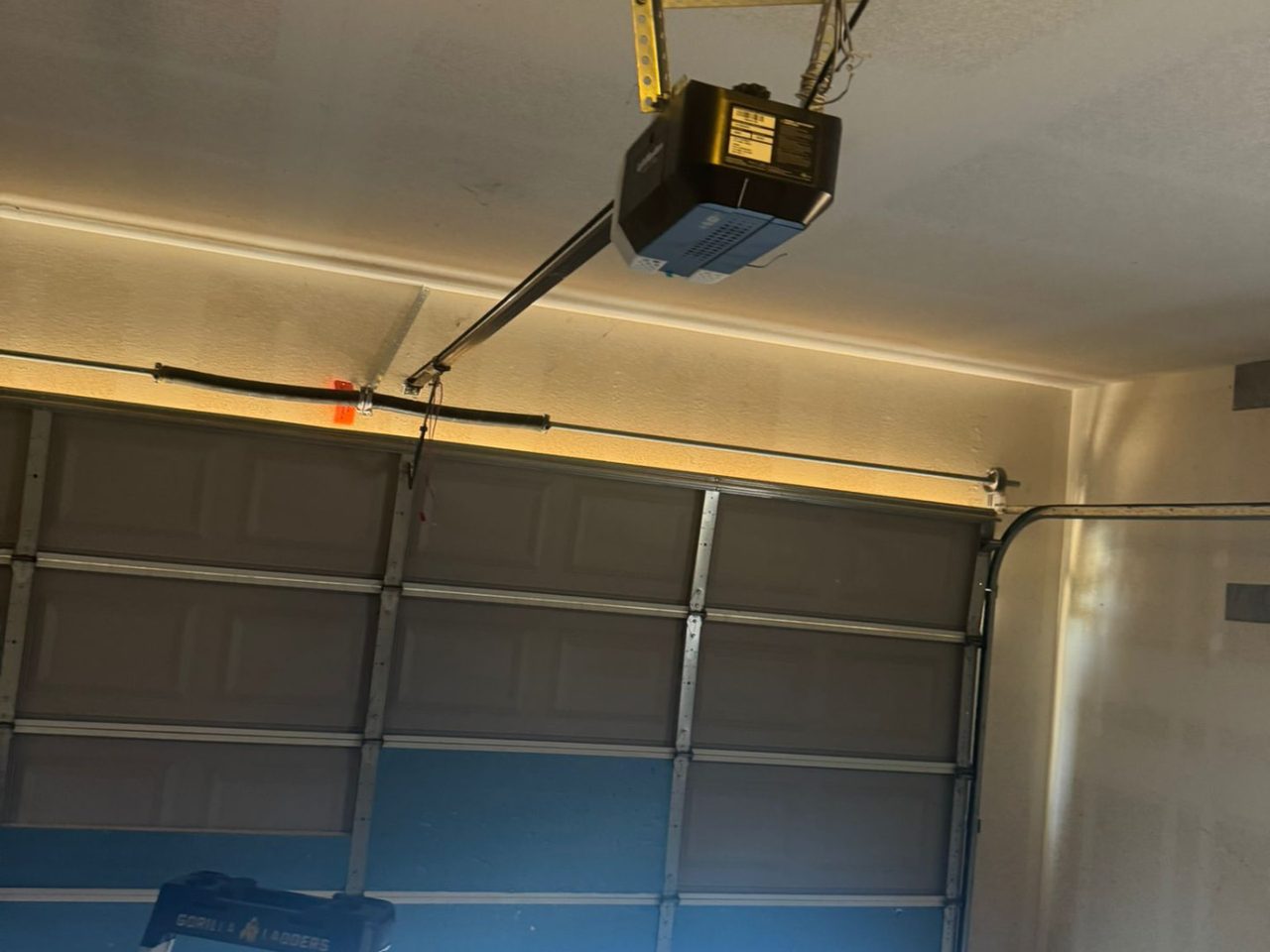 Ceiling-mounted garage door opener with rail and emergency release rope after installation