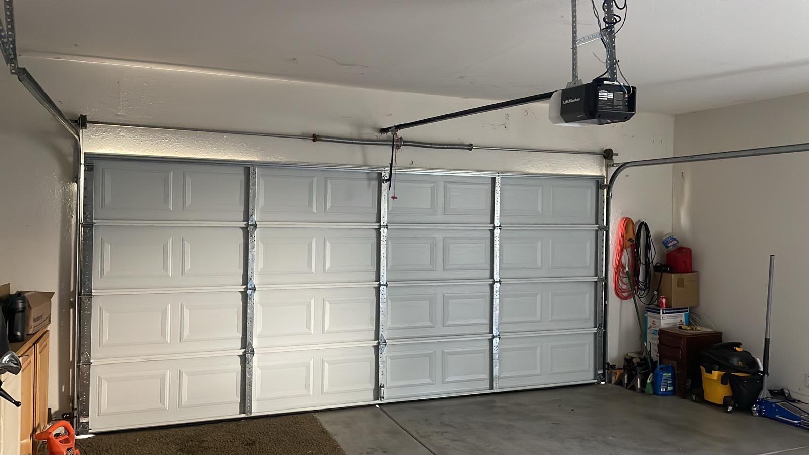 White sectional garage door with a LiftMaster opener installed in a Clovis, CA garage