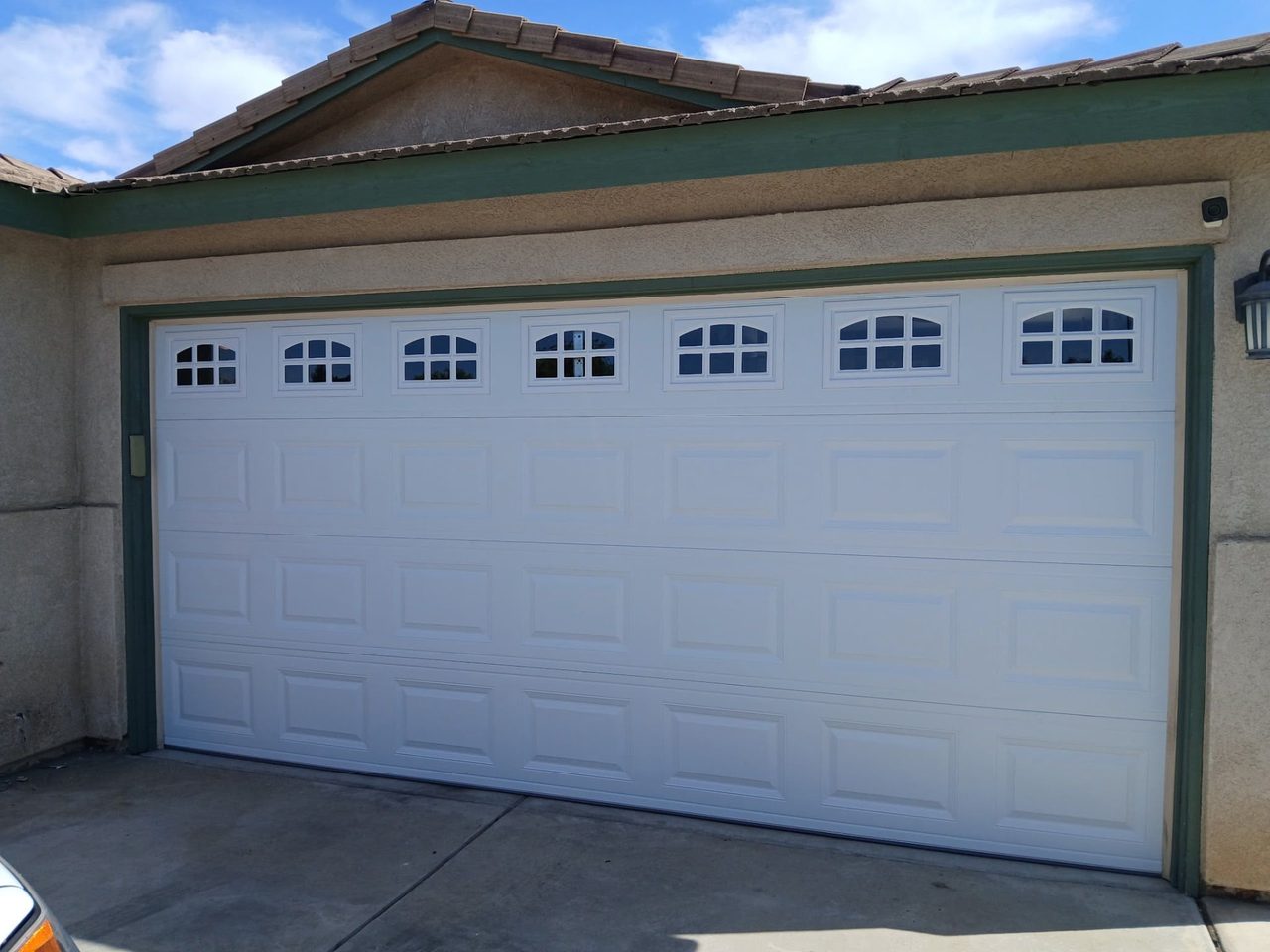 White carriage-style garage door with arched window inserts installed in Clovis, CA