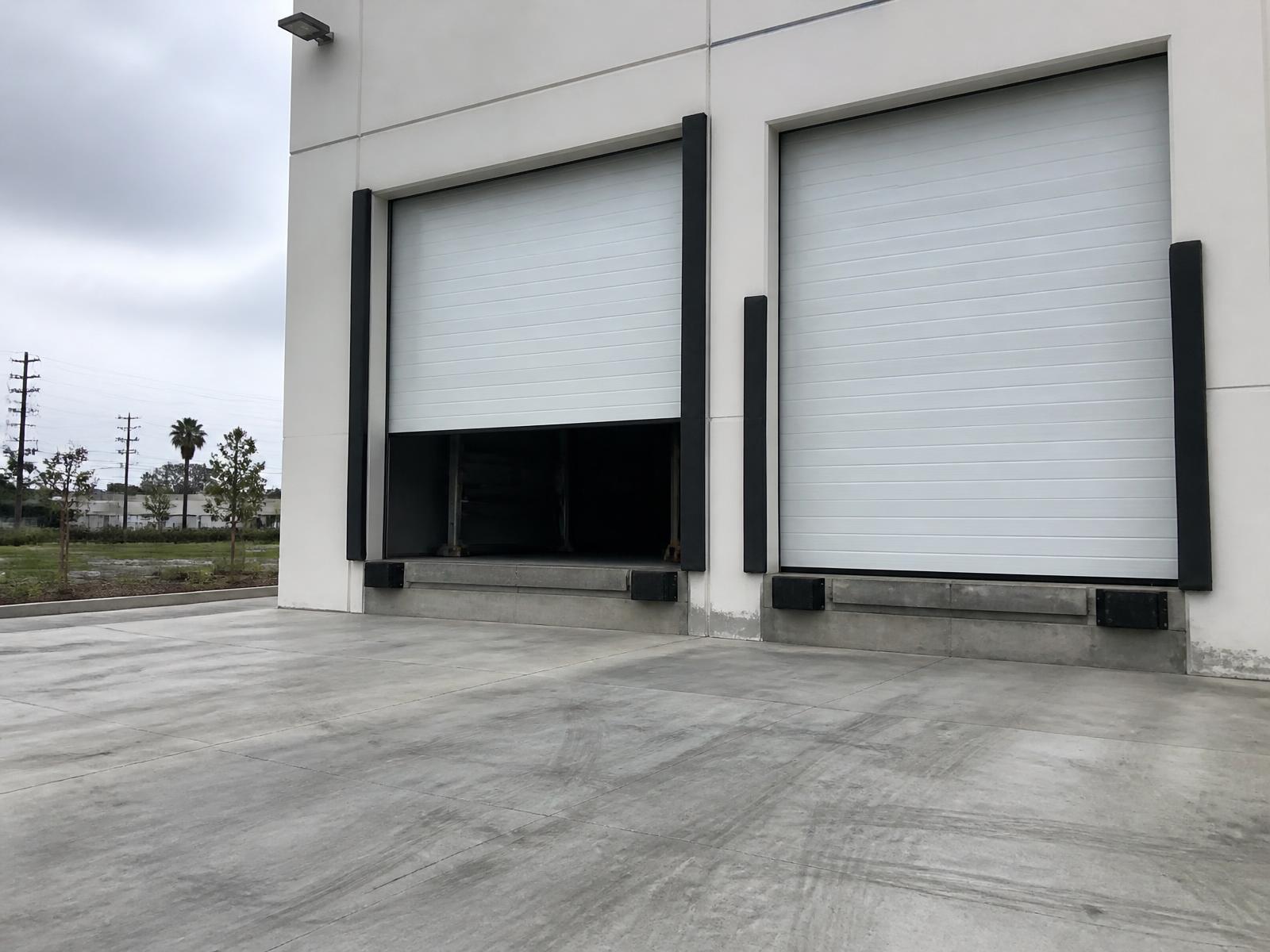 Commercial warehouse loading bay with two large insulated sectional garage doors